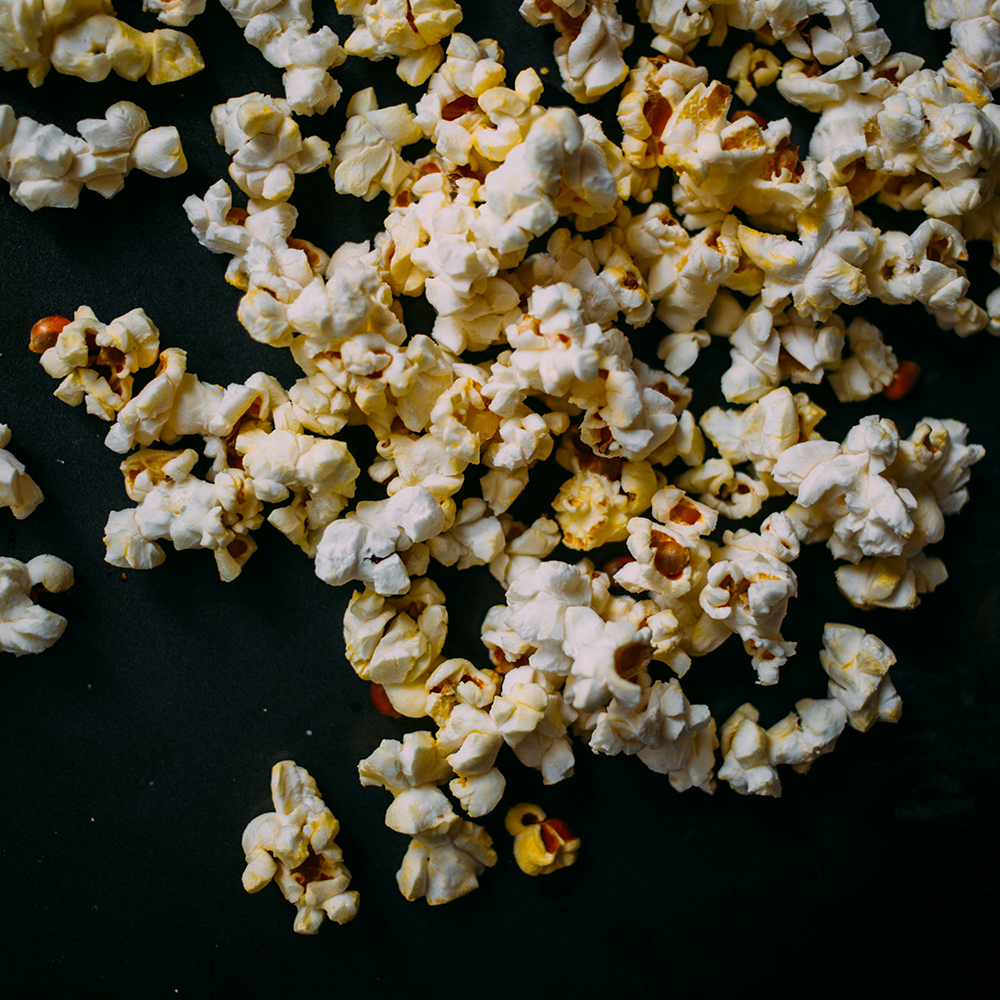 Close up photo of falling popcorn on a black background